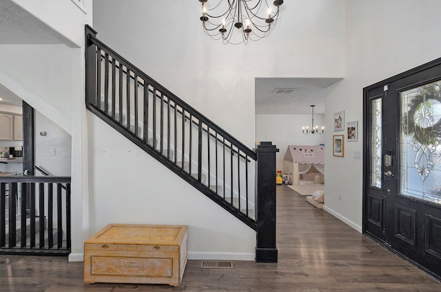 entryway with visible vents, dark wood-style floors, and a chandelier