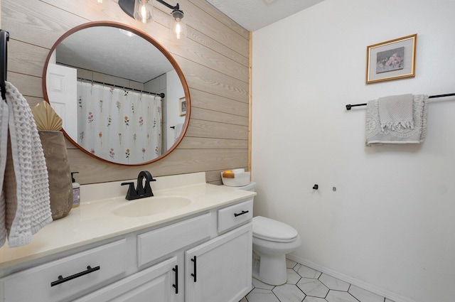 full bathroom featuring vanity, wooden walls, toilet, and a textured ceiling