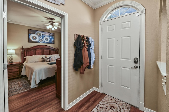 foyer entrance with dark wood-type flooring, a ceiling fan, baseboards, and ornamental molding