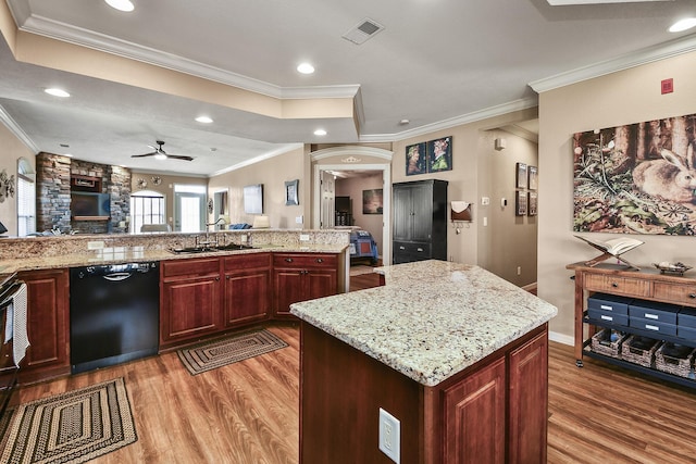 kitchen featuring light wood finished floors, visible vents, dark brown cabinets, dishwasher, and a sink