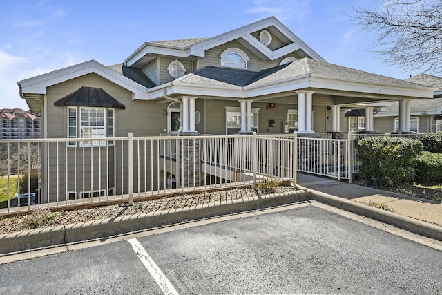 view of front of property with fence, a porch, and a shingled roof