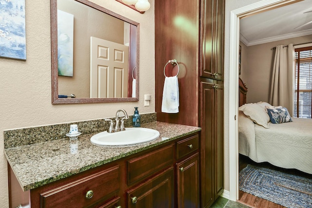 ensuite bathroom featuring connected bathroom, vanity, and crown molding