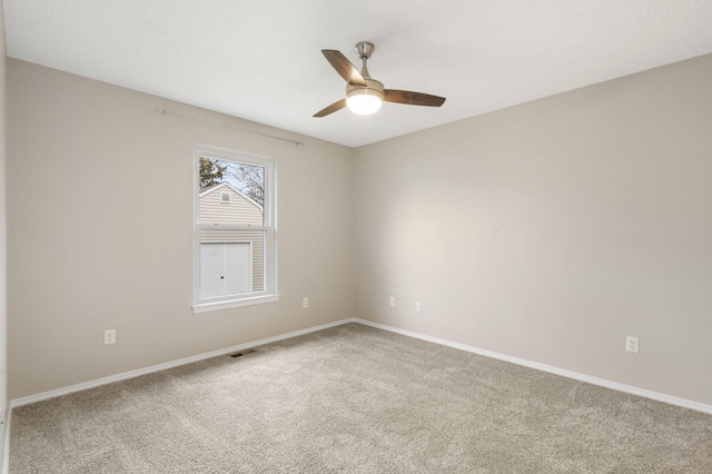 empty room with visible vents, ceiling fan, baseboards, and carpet