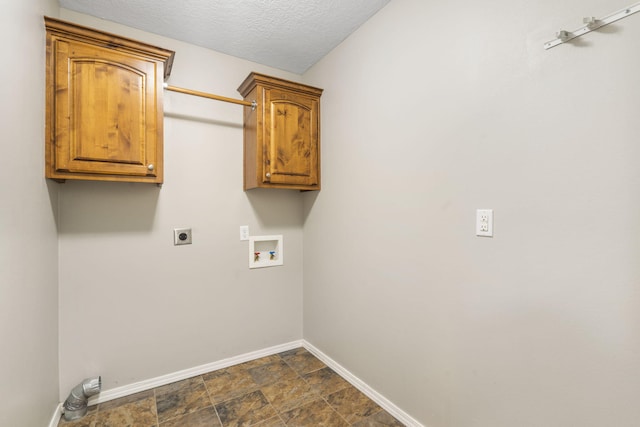 washroom with a textured ceiling, cabinet space, baseboards, hookup for an electric dryer, and hookup for a washing machine