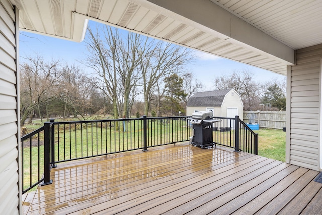 wooden deck featuring a storage shed, a yard, an outdoor structure, and a grill