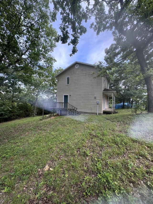 rear view of property with a lawn and a wooden deck