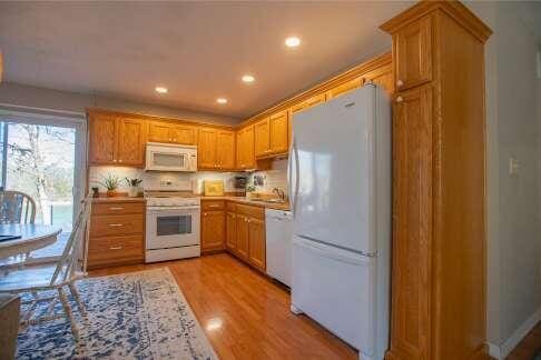 kitchen with recessed lighting, white appliances, light wood-style flooring, and light countertops