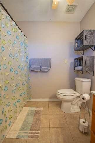 bathroom with a shower with shower curtain, baseboards, visible vents, tile patterned flooring, and toilet