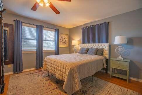 bedroom with wood finished floors, baseboards, and ceiling fan