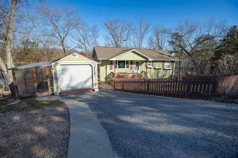 view of front of property featuring concrete driveway, an attached garage, and a fenced front yard