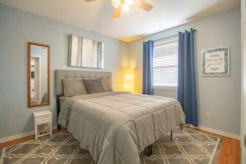 bedroom featuring ceiling fan, baseboards, and wood finished floors