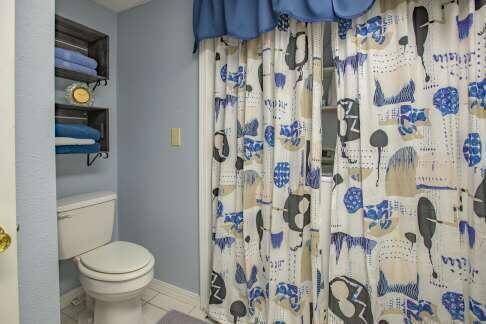 full bathroom featuring tile patterned floors, curtained shower, toilet, and baseboards