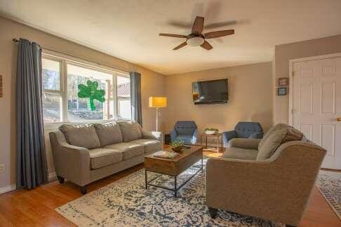 living area with wood finished floors and a ceiling fan