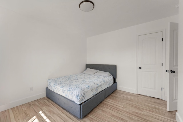 bedroom with baseboards and wood finished floors