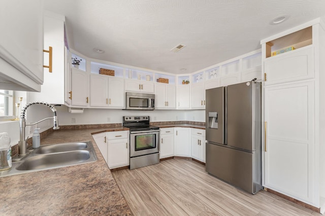 kitchen featuring white cabinetry, stainless steel appliances, and a sink