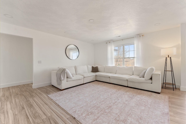 unfurnished living room featuring light wood finished floors and baseboards