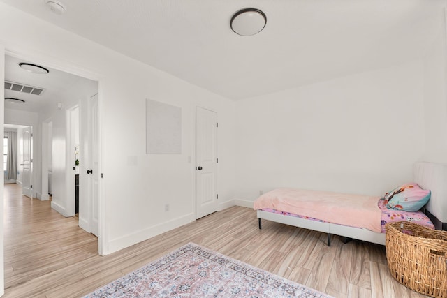 bedroom featuring visible vents, baseboards, and light wood-style flooring