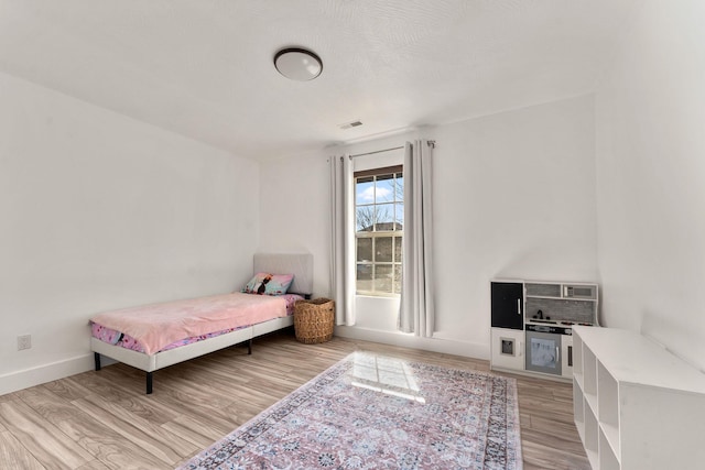 bedroom with light wood-style flooring and baseboards