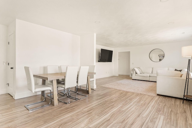 dining space with baseboards and wood finished floors