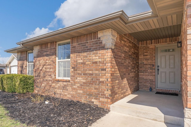 entrance to property featuring brick siding