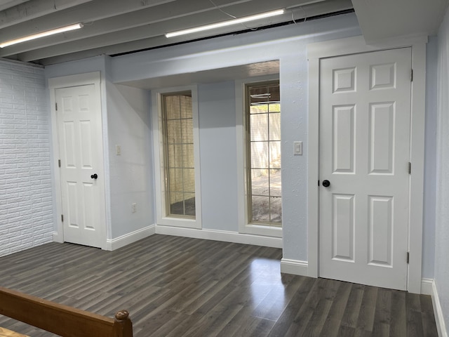 empty room with dark wood-type flooring and baseboards