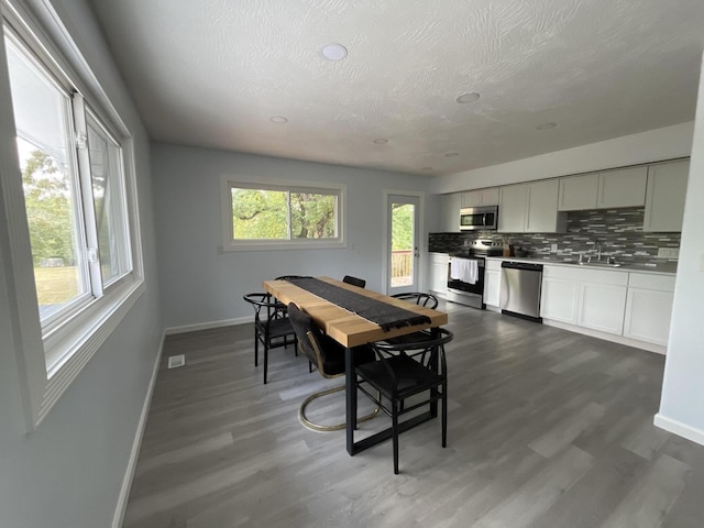 dining room featuring visible vents, a textured ceiling, baseboards, and dark wood-style flooring