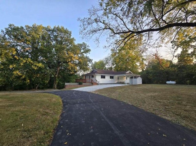 ranch-style home featuring driveway and a front lawn