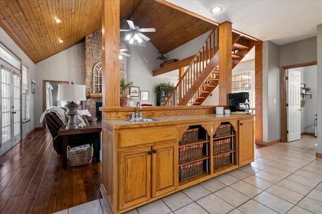 kitchen with a sink, baseboards, wood ceiling, and recessed lighting