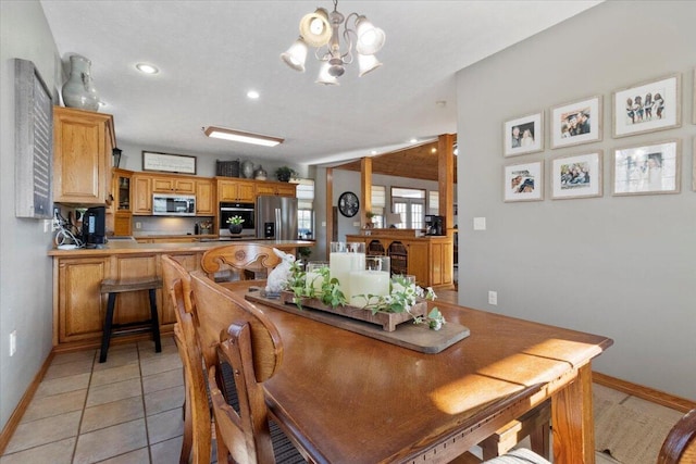 dining room with light tile patterned flooring, recessed lighting, baseboards, and an inviting chandelier