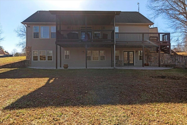 rear view of property featuring a yard, a patio, and a wooden deck