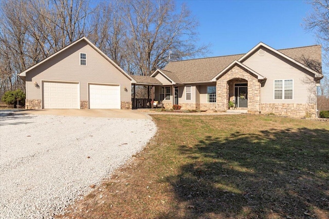 ranch-style house featuring gravel driveway, a front lawn, a porch, a garage, and stone siding