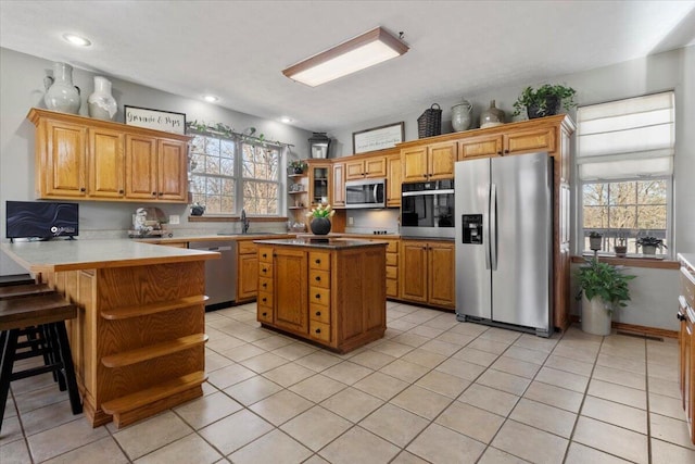 kitchen with open shelves, a wealth of natural light, a peninsula, and appliances with stainless steel finishes