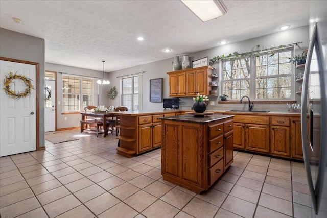 kitchen featuring a sink, brown cabinets, a center island, and open shelves