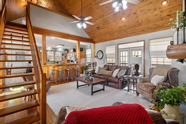 living room featuring stairway, wooden ceiling, french doors, high vaulted ceiling, and a bar