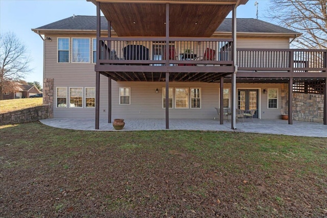 back of property featuring a patio area, a lawn, a shingled roof, and a deck