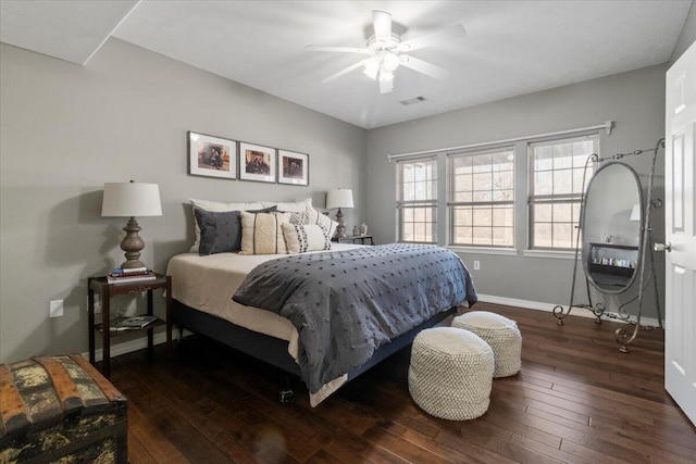 bedroom with ceiling fan, visible vents, baseboards, and hardwood / wood-style floors