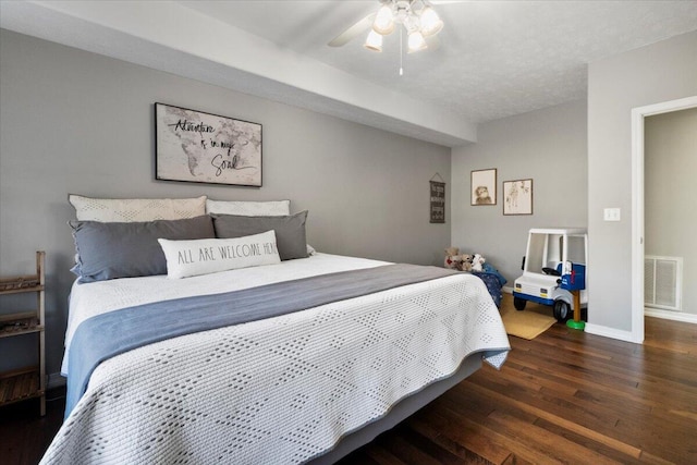 bedroom with a ceiling fan, wood finished floors, visible vents, baseboards, and a textured ceiling