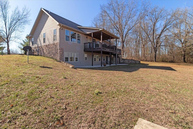 back of property with a deck, a lawn, and a patio