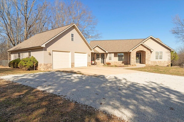 single story home with stone siding and driveway