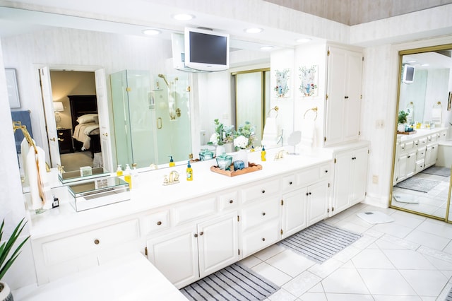 full bathroom featuring tile patterned floors, double vanity, a stall shower, and ensuite bathroom