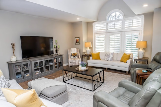 living room with a wealth of natural light, lofted ceiling, wood finished floors, and recessed lighting