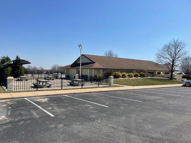 view of property with uncovered parking and fence