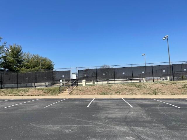 uncovered parking lot featuring fence