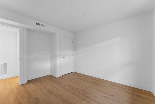 empty room with visible vents, baseboards, and light wood-style floors