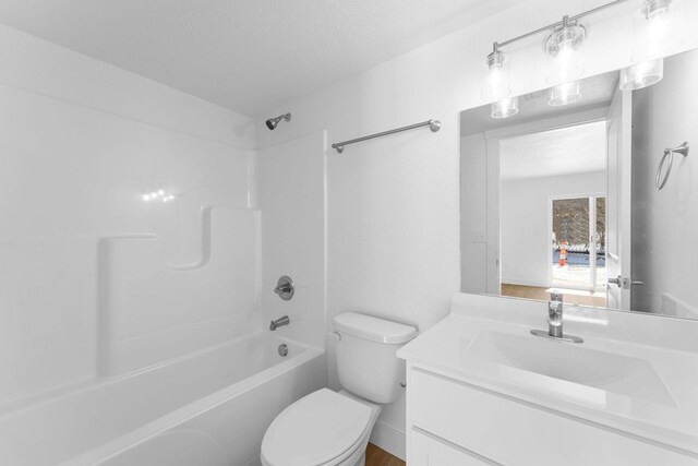 bathroom featuring toilet, vanity, and shower / tub combination