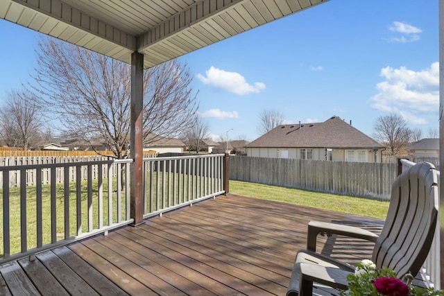 wooden deck with a residential view, a lawn, and a fenced backyard