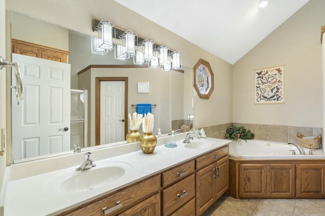 full bath with a sink, lofted ceiling, a garden tub, and tile patterned floors