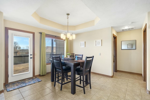 dining area with light tile patterned floors, visible vents, a raised ceiling, and baseboards