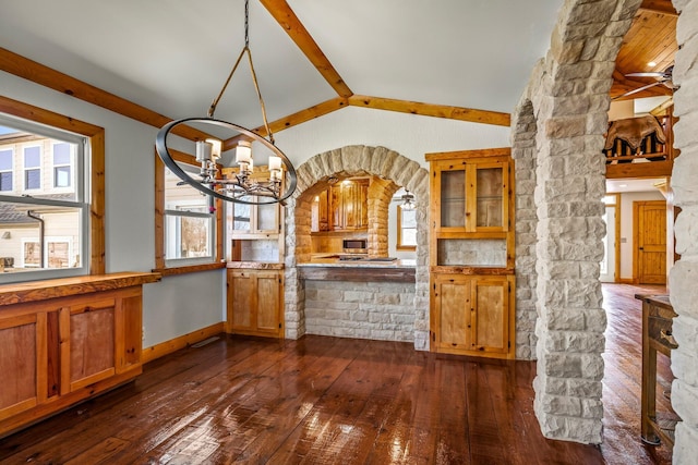 kitchen featuring dark wood-type flooring, pendant lighting, brown cabinetry, baseboards, and vaulted ceiling with beams