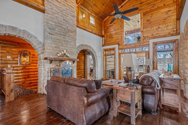 living area featuring hardwood / wood-style floors, a ceiling fan, arched walkways, and high vaulted ceiling